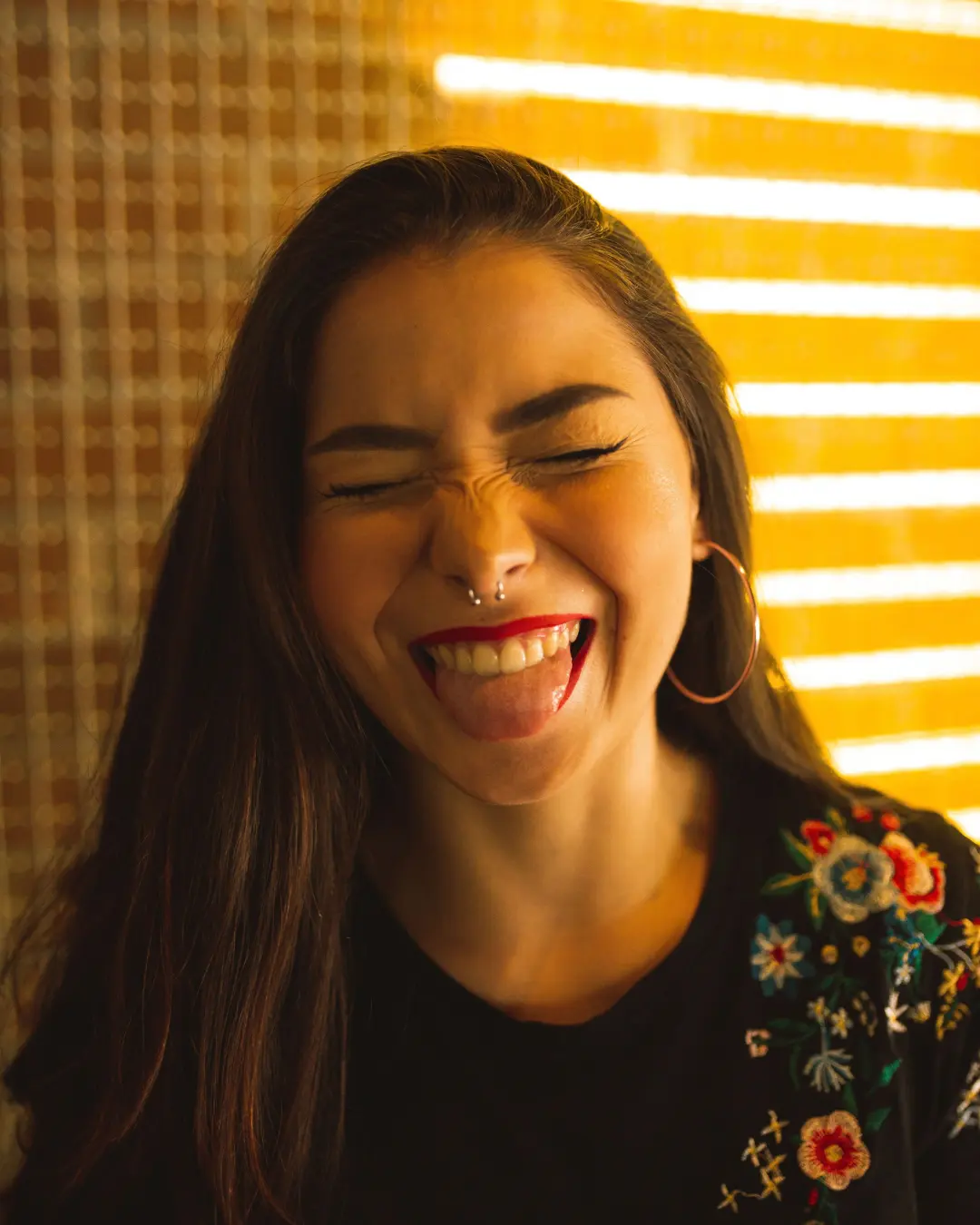 A woman smiling in warm striped sunlight