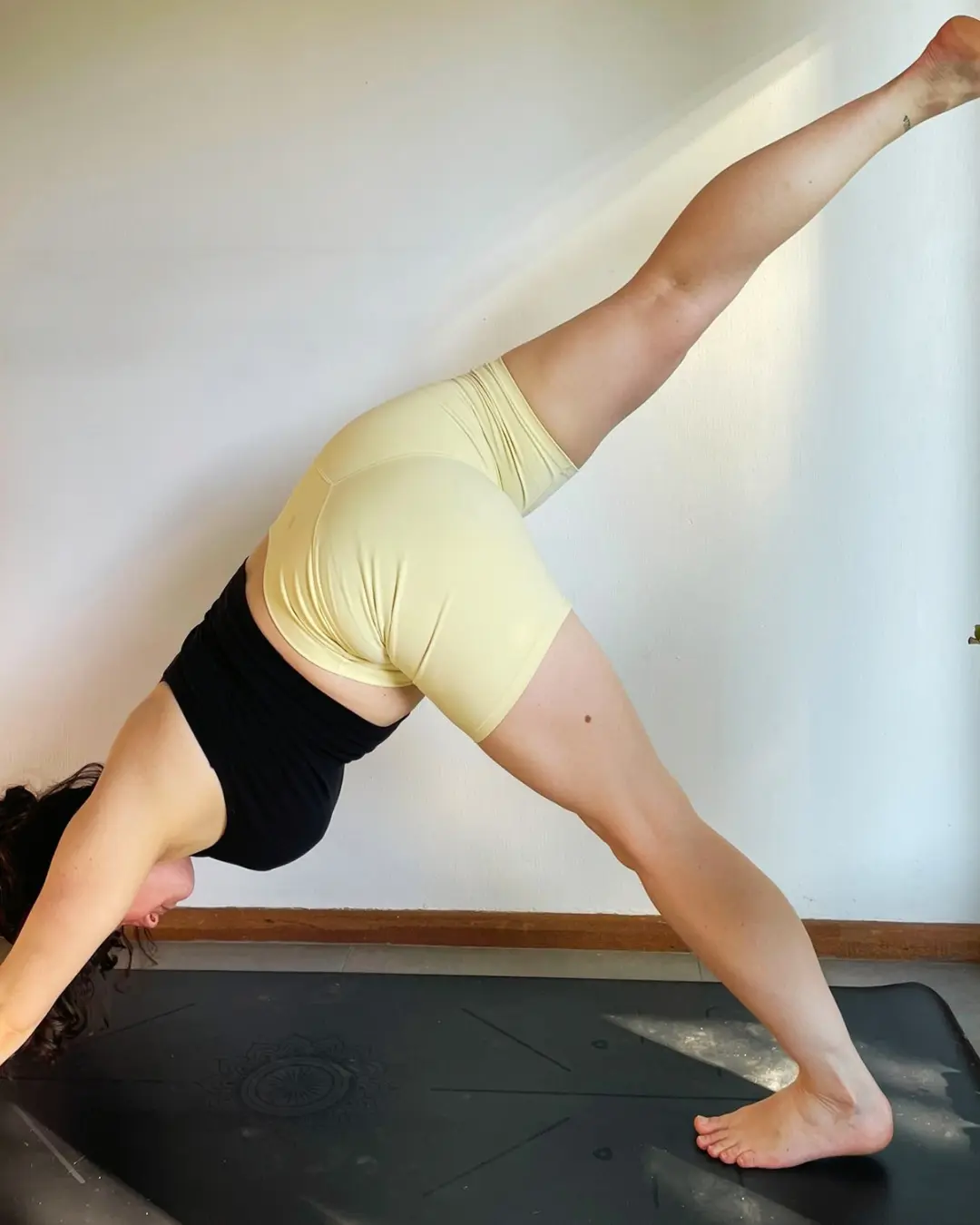 Kerry practising a strong standing yoga pose at home